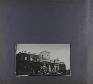 One photo of a substantial 2-storey official building with ivy covering much of the walls, in its garden.
