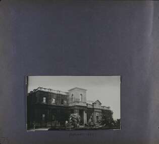 One photo of a substantial 2-storey official building with ivy covering much of the walls, in its garden.