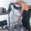 Kitchen worker spraying large aluminium round containers.
