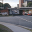 Railway underpass with two red cars in the foreground.