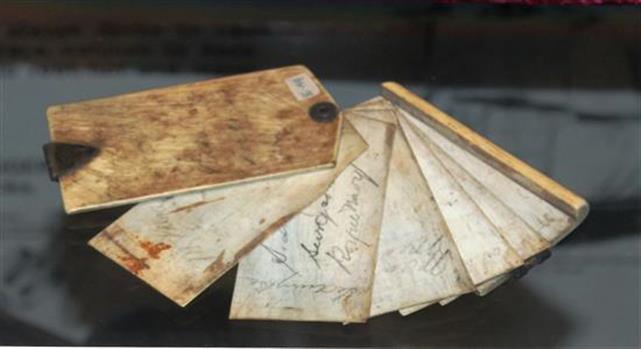 Top vies of note book shown in the open position. Frons and back covers are made of scrimshaw [whale bone].