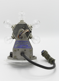 An electrical device with a rotating lamp holder containing 6 light globes attached to a motor with an electrical lead attached to an industrial pin socket.