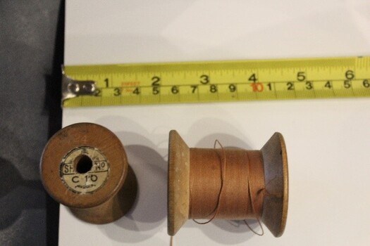 2 wooden cotton reels with thread