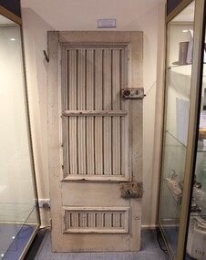 Slatted wooden cabin door painted white with two locks