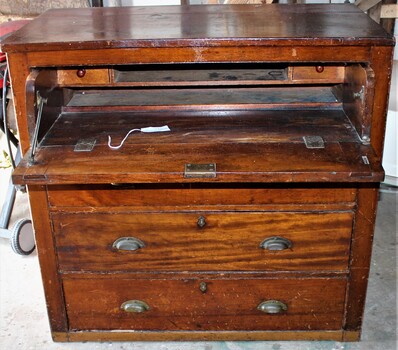 Solid timber desk with two drawers and drop down drawer which becomes a writing desk compartment revealing a shelf and two small drawers.
