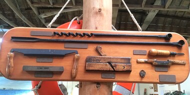 A timber display board holding shipwright tools