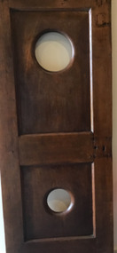 A timber door with two round 'port hole' type windows.