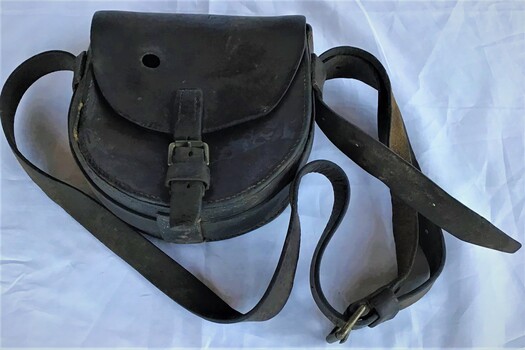 Top view of leather pouch with clasping buckle and shoulder strap.