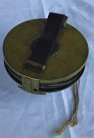 Surveying tape housed in brass reel and held in a leather pouch about 100 feet long.