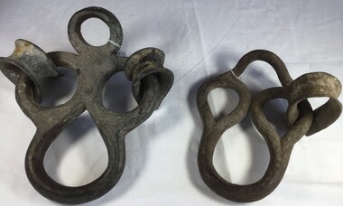Two large metal rings with attached rope links used for attaching to sails.