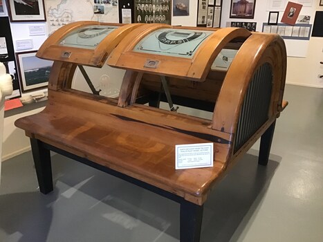 Side top view of a timber skylight showing two panels in the open position. Limber is stained and windows are frosted with PPPS inscribed. 