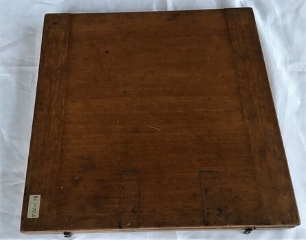 Outside view of a wooden box which houses a brass drawing circle.