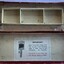 Rectangular cardboard box with separate compartments to hold beam compass and components. Outer colour is red with instructions on the inside. Box is badly damaged.a
