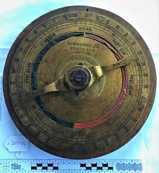 Circular brass plaque inscribed with J5 North Sea 1917 1918 made from a piece of navigational equipment used on the submarine J5 mounted on wood