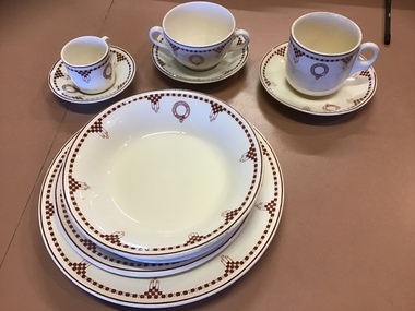 8 pieces of china with an Art Deco edge pattern showing the crest of the Melbourne Steamship Co. and as used on board the MV Duntroon