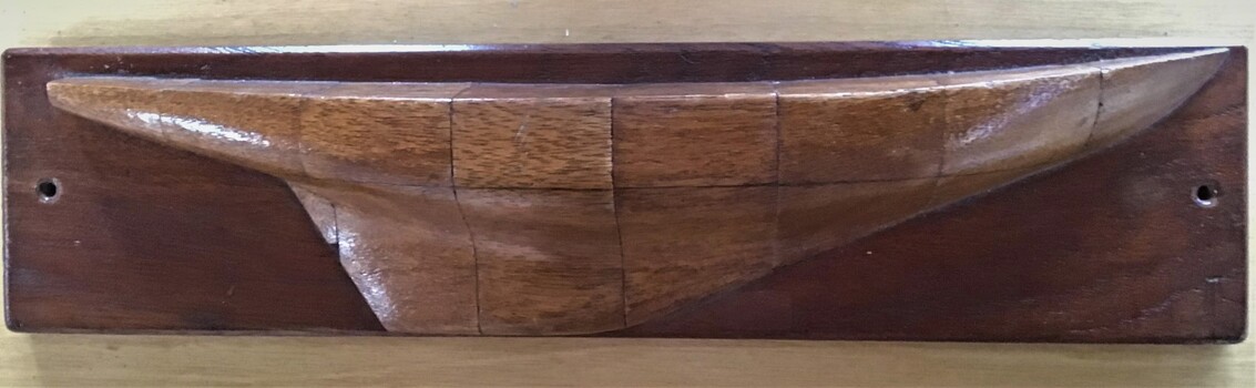 Half model of an unknown yacht in timber showing scale grid lines and mounted on a timber board.