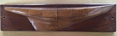 Half model of an unknown yacht in timber showing scale grid lines and mounted on a timber board.