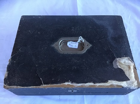 Black portable writing desk with brass handle; closed view