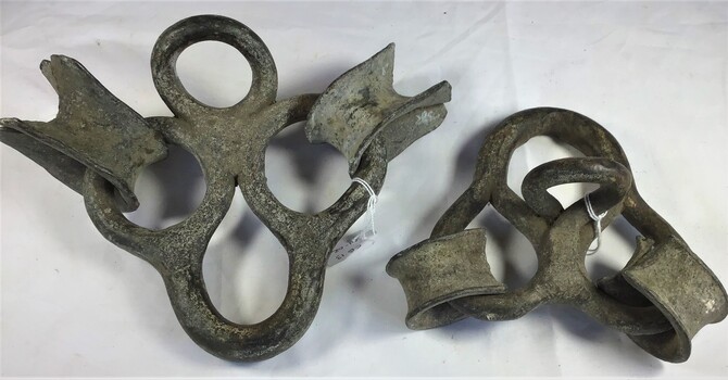 Two metal spectacle rings or irons used to attach sails to rope