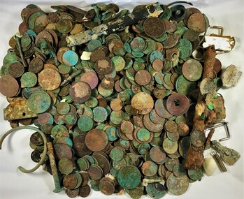 A collection of various coin and other metal objects retrieved from the ocean floor.