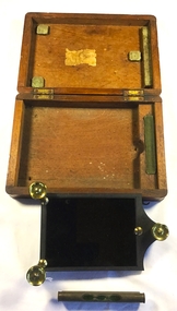 An open wooden box which held a sun reflector and a spirit level 