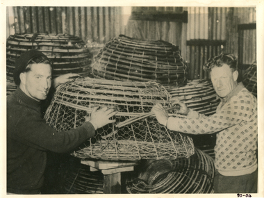 Two Queenscliff fishermen, William Withers and Edward Ryan stacking crayfish pots.