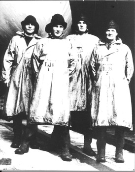 Black & white photograph of 4 lifeboat crew in full waterproof dress