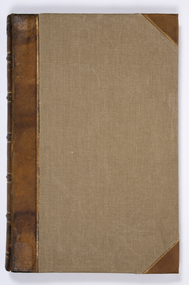 Front view of a large leather bound atlas with light brown fabric covers and gold trim.