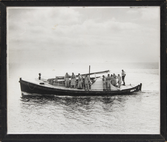 A framed black and white photograph of the Queenscliff lifeboat with 1970 crew on board.