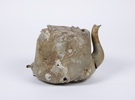 Aluminium teapot showing extensive damage, corrosion and encrustations. 