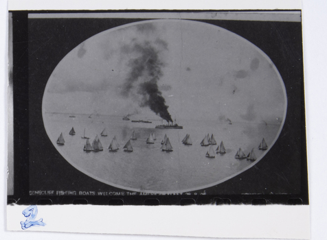 A photograph of an early photograph mounted on an oval mat showing the Queenscliff fishing fleet welcoming the American Fleet into Port Phillip.