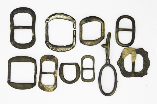 10 horse harness buckles of various sizes and shapes some corroded and some encrusted recovered from the wreck of the 'Schomberg'