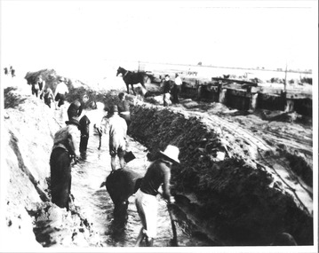 12 men digging out the channel by hand shovel