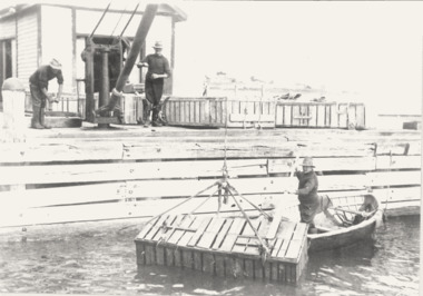 Black & white photograph of Queenscliffe cray fishermen unloading cray crate.
