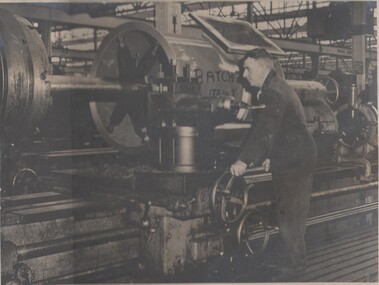 Photograph - BENDIGO ORDINANCE FACTORY COLLECTION: MAN OPERATING AND MANUFACTURING A SECTION OF AN EXHAUST MANIFOLD FOR DOXFORD OPPOSED PISTON DIESEL ENGINE