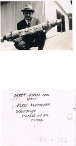 Photograph - BILL ASHMAN COLLECTION: MAN HOLDING A LARGE DIESEL FUEL SCALEBUOY UNIT