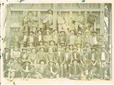 Photograph - BLACK AND WHITE PHOTOS: A GROUP OF MINERS AGAINST A WOODEN WALL