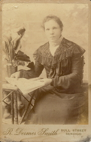 Photograph - YOUNG WOMAN SEATED AT TABLE