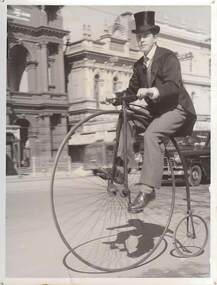 Photograph - YOUNG MALE IN COSTUME RIDING PENNY FARTHING BICYCLE IN PALL MALL, c.1951