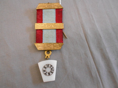 Accessory - JOHN FREDERICK HARPER COLLECTION: BRASS AND RIBBON LAPEL BADGE, 1950-1990's