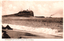 This black-and-white card shows waves breaking on a beach below a coastal headland; on the card is printed “Ex.184. NEWCASTLE N.S.W. ‘Nobby’s’ from the Beach.”