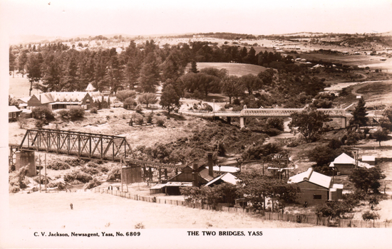 This black-and-white card shows two bridges crossing a rural valley with buildings and trees; on the card is printed “C. V. Jackson, Newsagent, Yass, No. 6809” and “THE TWO BRIDGES, YASS”.