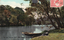 This coloured card shows a person reclining beside a rowboat on a calm, tree-lined lake; on the card is printed “The Dam, National Park, New South Wales” and “N.G. 58.”