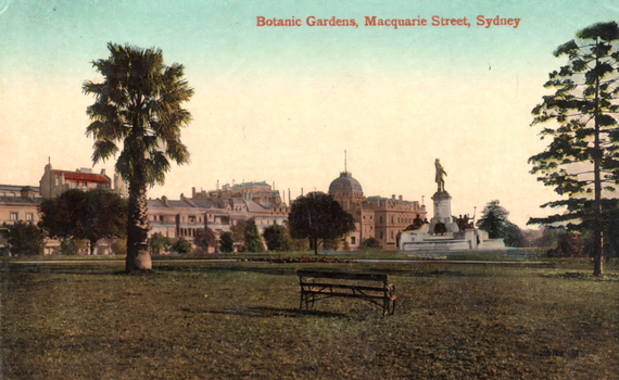 This coloured card shows a garden lawn with trees, a monument and city buildings; on the card is printed “Botanic Gardens, Macquarie Street, Sydney”.