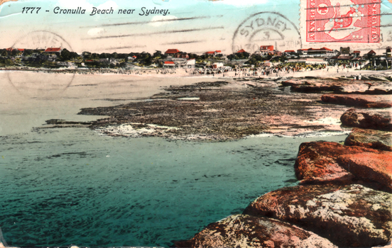 This coloured card shows a rocky shoreline overlooking a crowded beach and coastal settlement; on the card is printed “1777 - Cronulla Beach near Sydney.”
