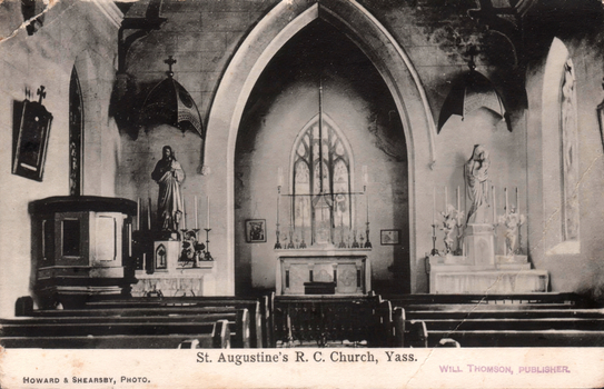 This black-and-white card shows the interior of a church with pews, altars and religious statues; on the card is printed “St. Augustine’s R. C. Church, Yass.”, “HOWARD & SHEARSBY, PHOTO.” and “WILL THOMSON, PUBLISHER.”