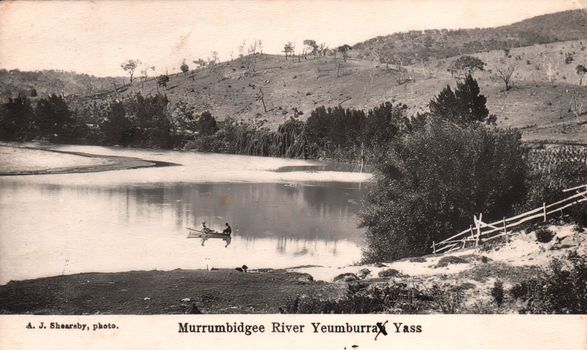 This black-and-white card shows two people in a boat on a river beside a wooded hillside; on the card is printed “A. J. Shearsby, photo.” and “Murrumbidgee River Yeumburra Yass”.