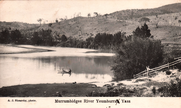 1405.143 This black-and-white card shows two people in a boat on a river beside a wooded hillside; on the card is printed “A. J. Shearsby, photo.” and “Murrumbidgee River Yeumburra Yass”.
