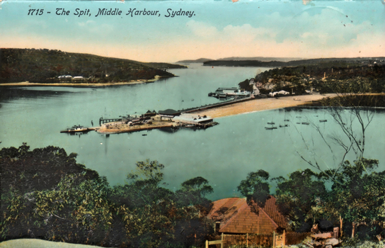 This coloured card shows an elevated view of a harbour, sand spit, wharves and small boats; on the card is printed “1715 - The Spit, Middle Harbour, Sydney.”