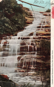 This coloured card shows cascades flowing over rocky ledges; on the card is printed “Cascades over Katoomba Falls, New South Wales.”